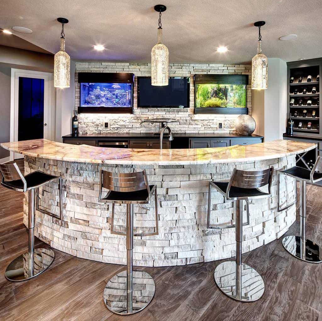 Modern wet bar with stacked stone facade, marble countertop, and metal bar stools.