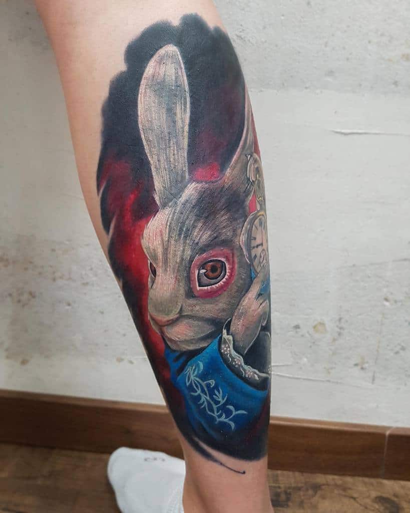 Realistic and colorful tattoo of the White Rabbit from Alice in Wonderland, holding a pocket watch and wearing a blue vest, a dramatic red background