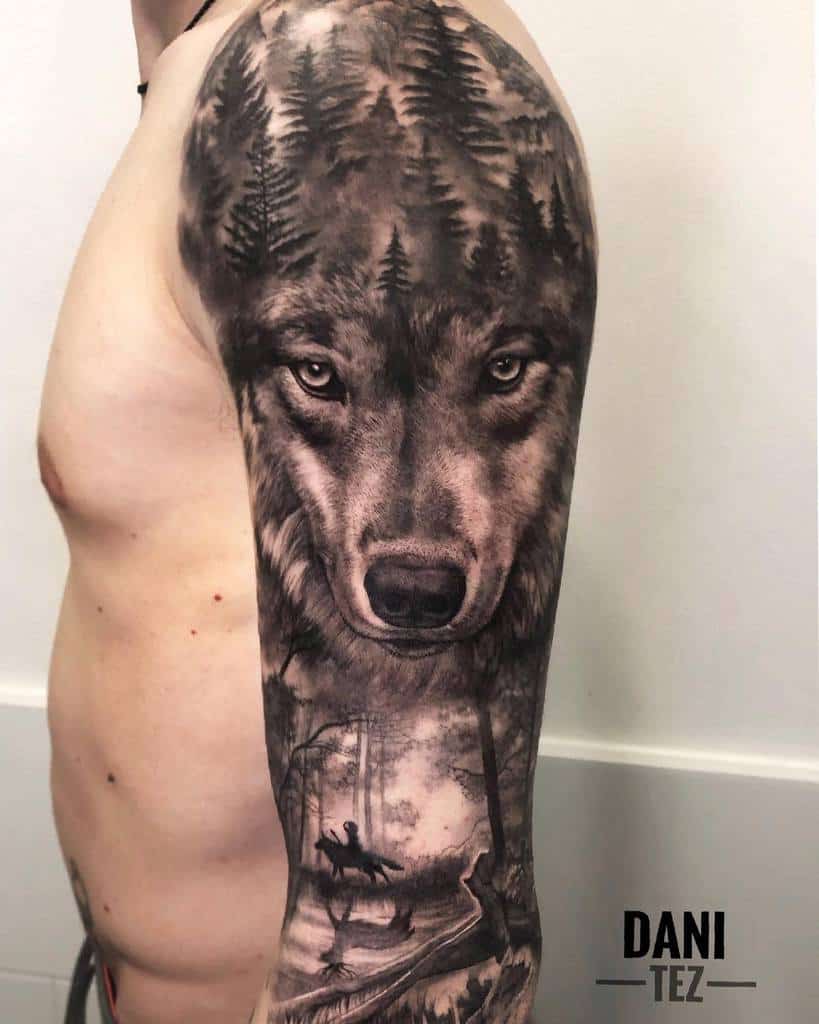Arm tattoo featuring a wolf with forest scenery