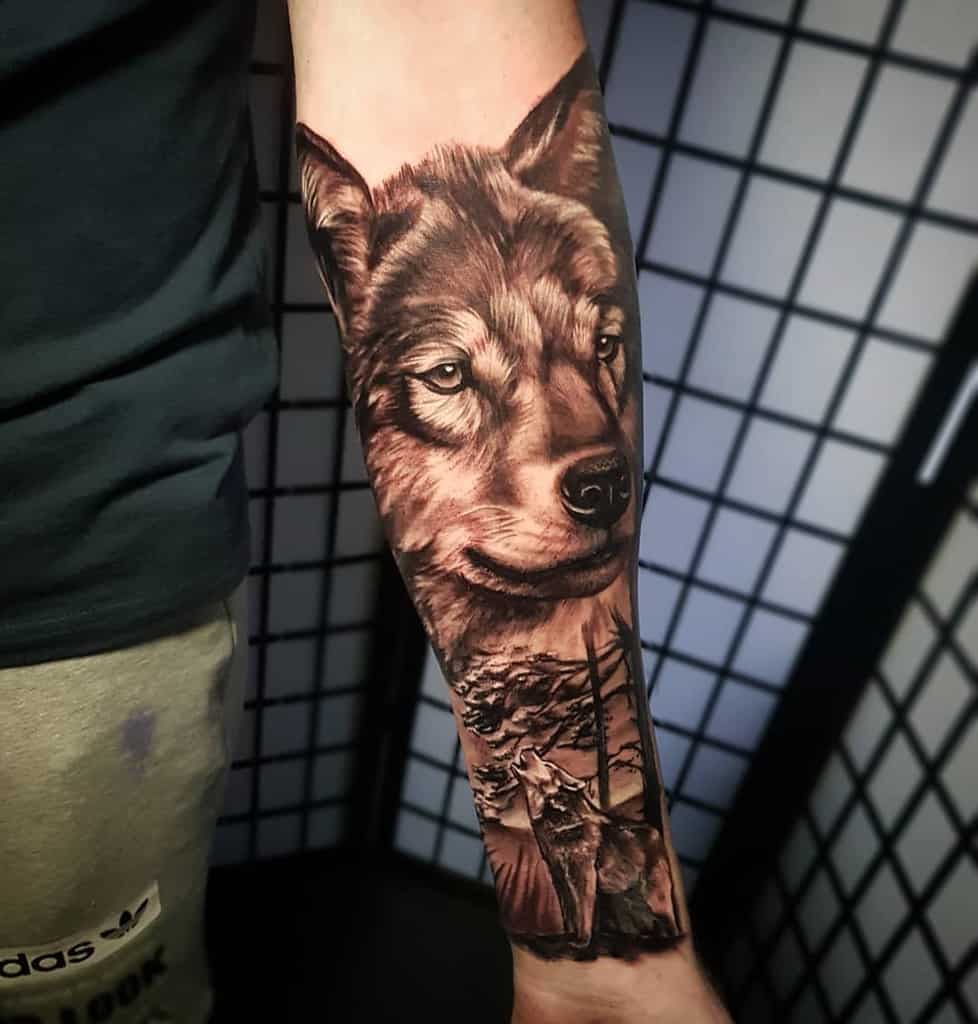 Forearm tattoo of a wolf with trees in the background