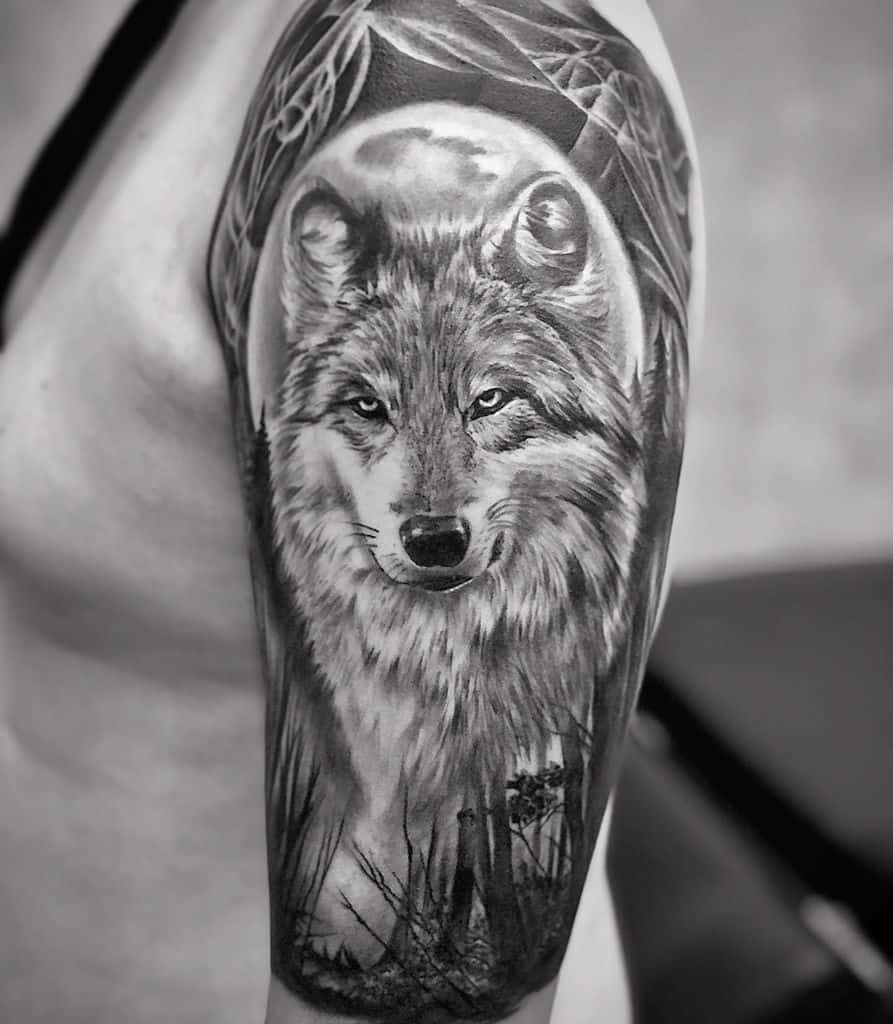Black and white wolf tattoo on a person's upper arm