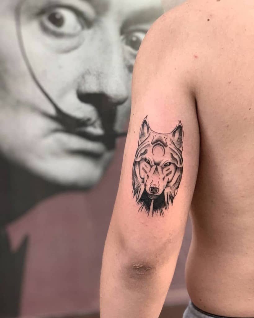 A tattoo of a wolf on an upper arm