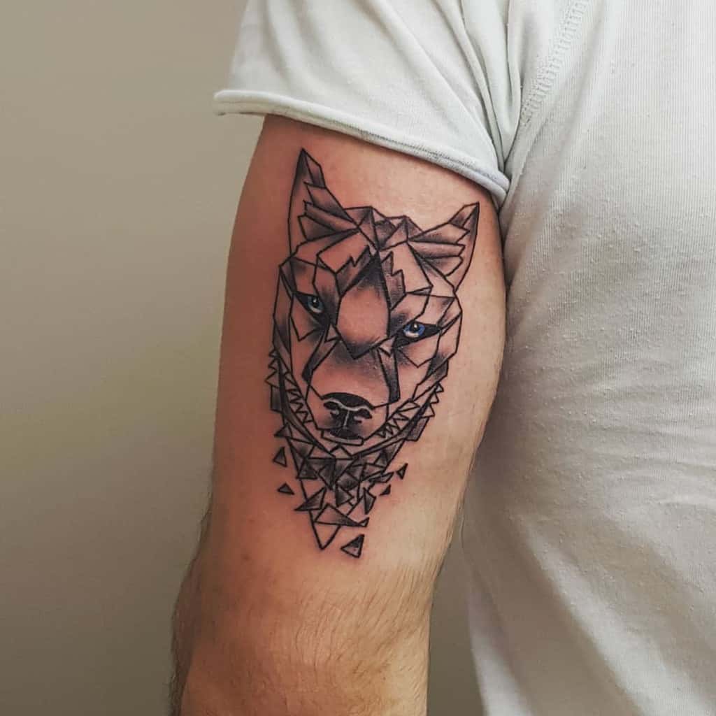Tattoo of a geometric wolf design on an upper arm