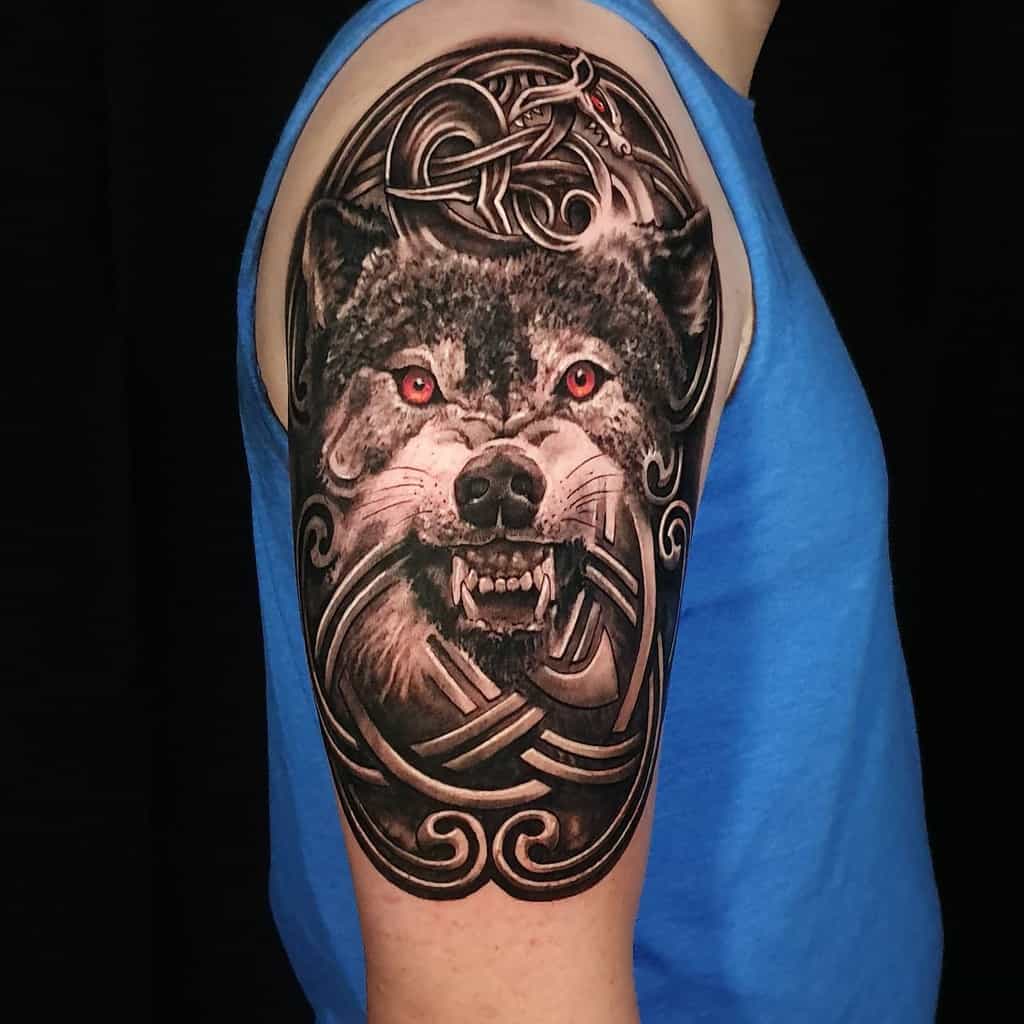 Detailed wolf tattoo with red eyes and intricate Celtic patterns on an upper arm