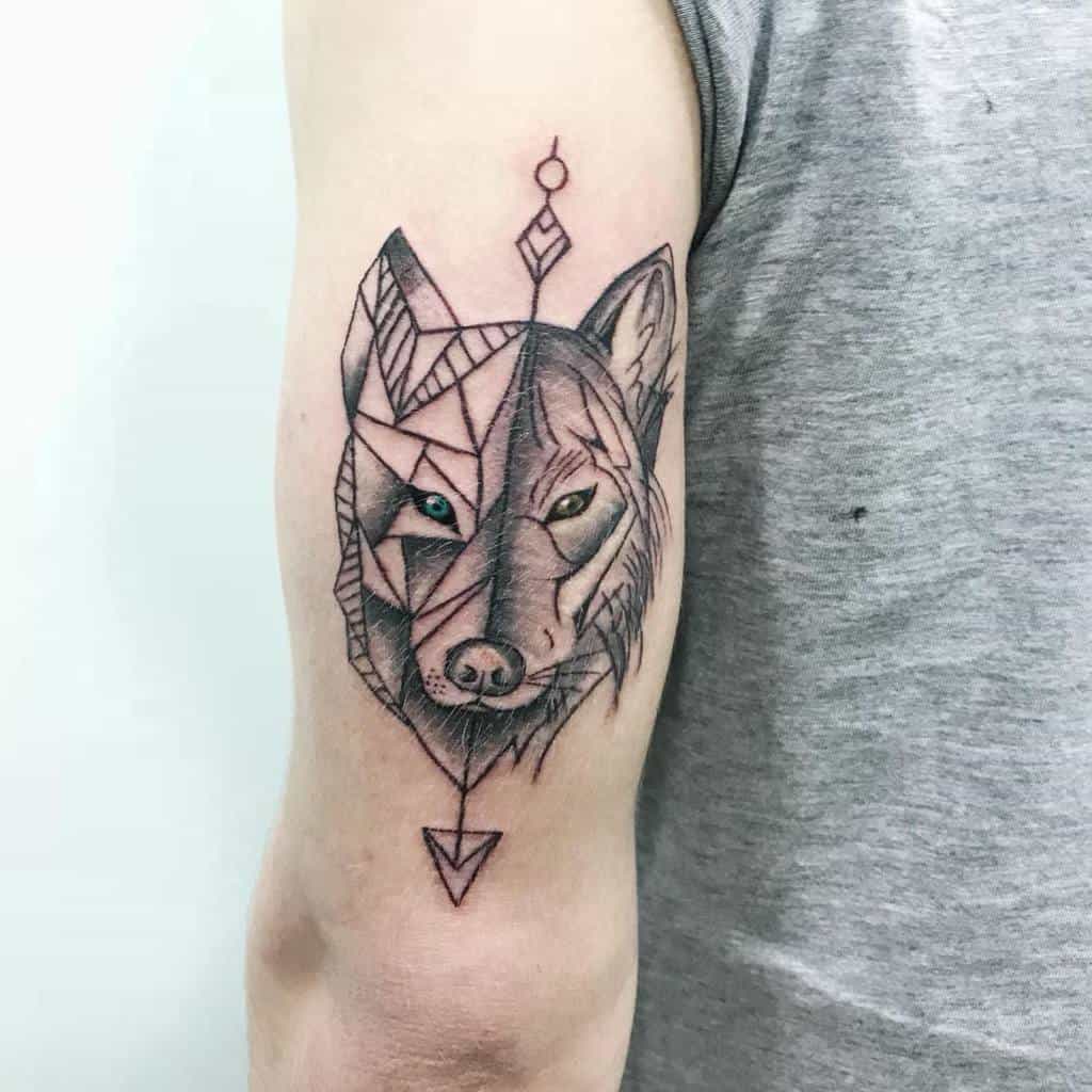 Upper arm tattoo featuring a wolf with a unique design, blending geometric shapes on one side of the face with realistic shading on the other, giving the tattoo a modern and artistic feel