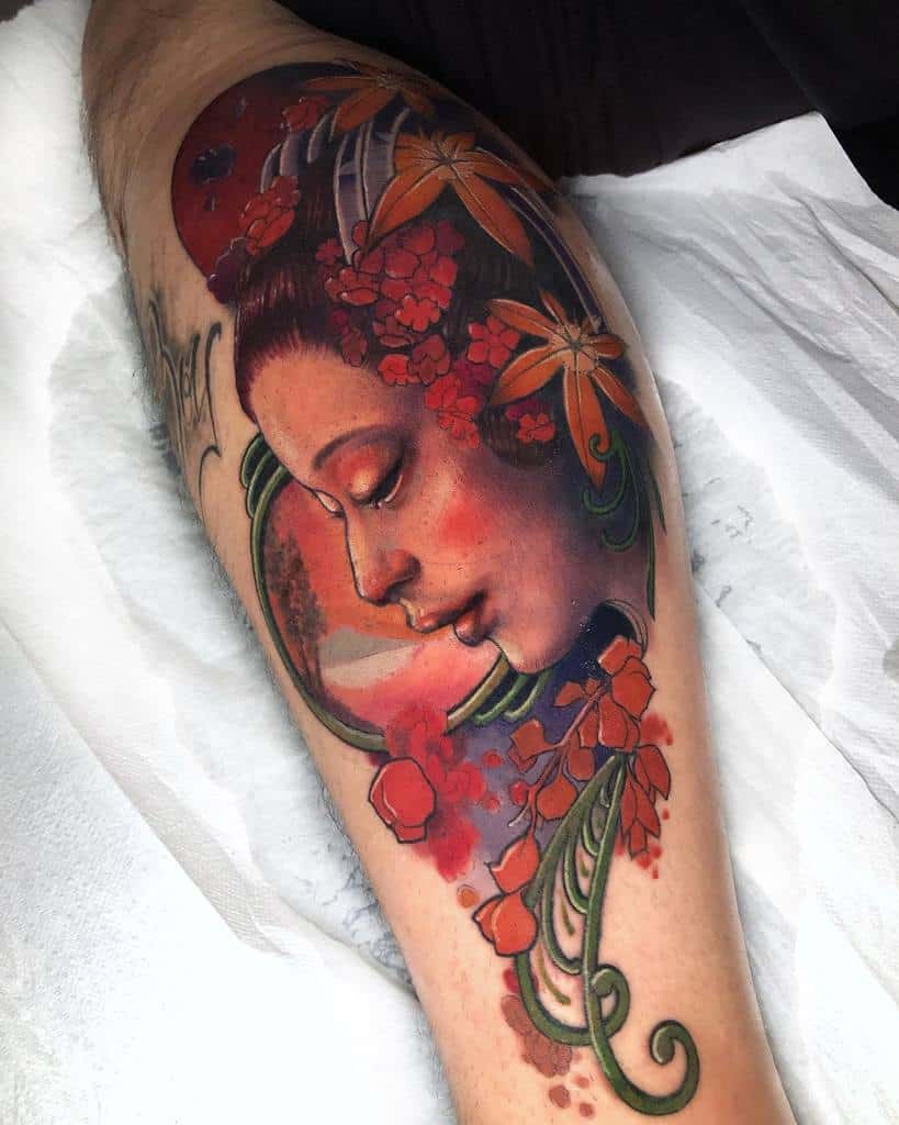 Art Nouveau-style tattoo of a woman's serene profile with flowing hair, red floral accents, and intricate green ornamental designs