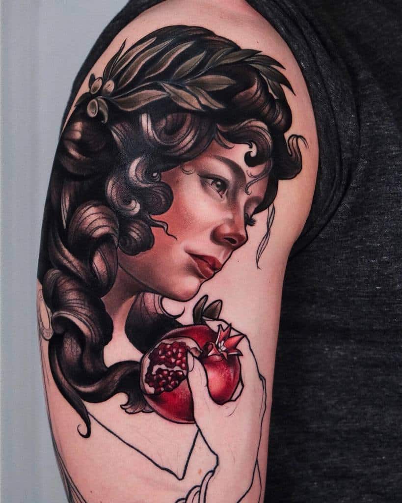 Art Nouveau tattoo of a woman with dark flowing hair, a laurel crown, and a red pomegranate in hand