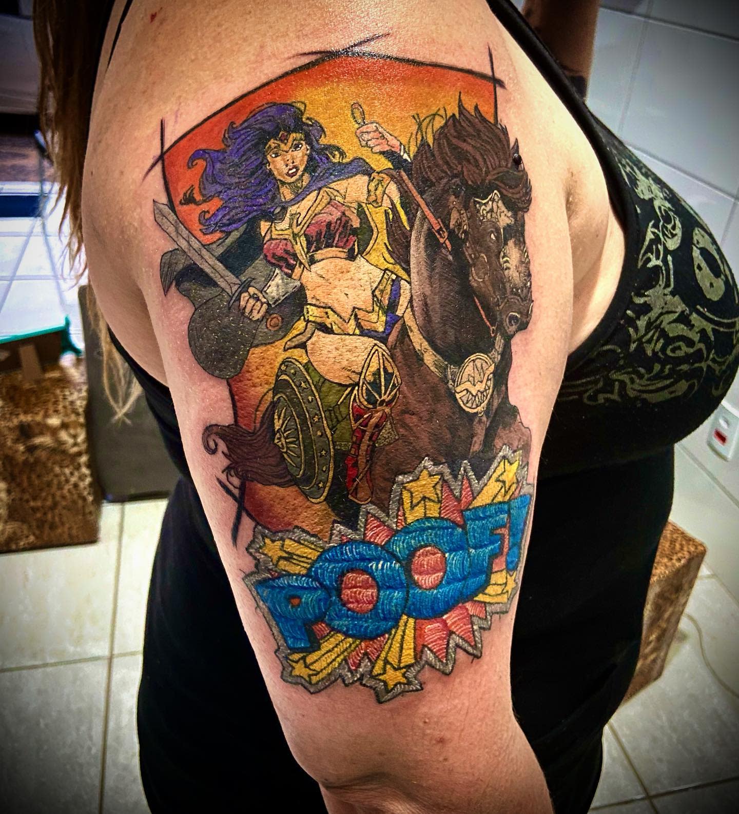 Tattoo of Wonder Woman in a dynamic action pose, riding a powerful horse into battle
