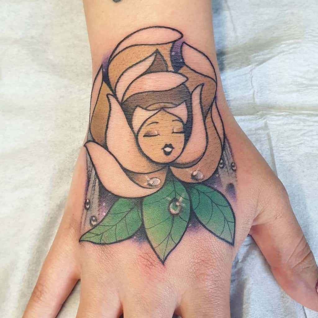 A delicate tattoo of a talking flower from Alice in Wonderland, blending a feminine face with petals and leaves, accented with dewdrops