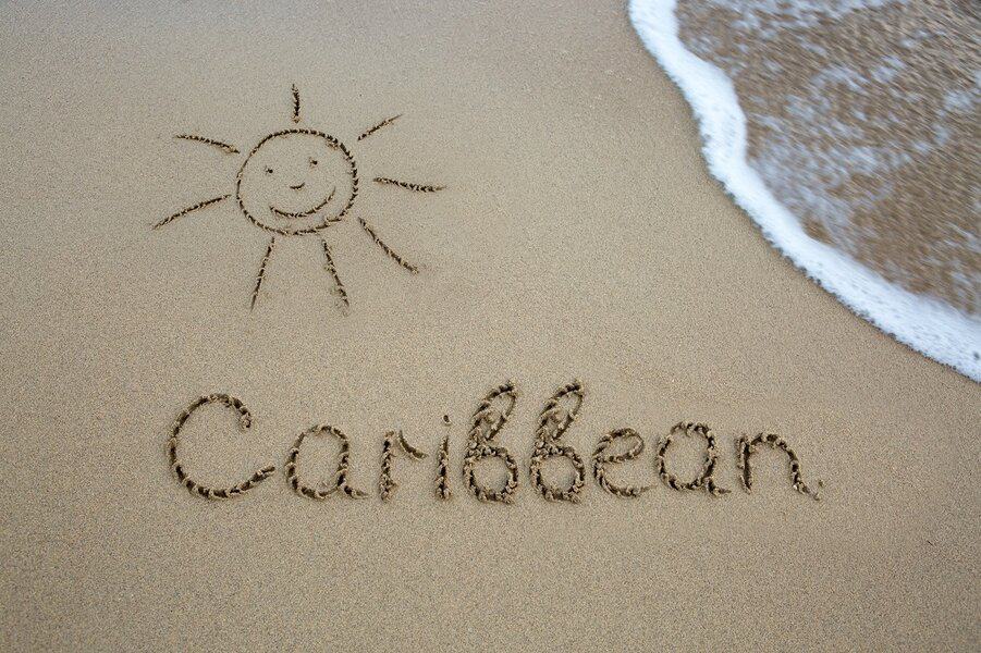 Word Caribbean written on the sand