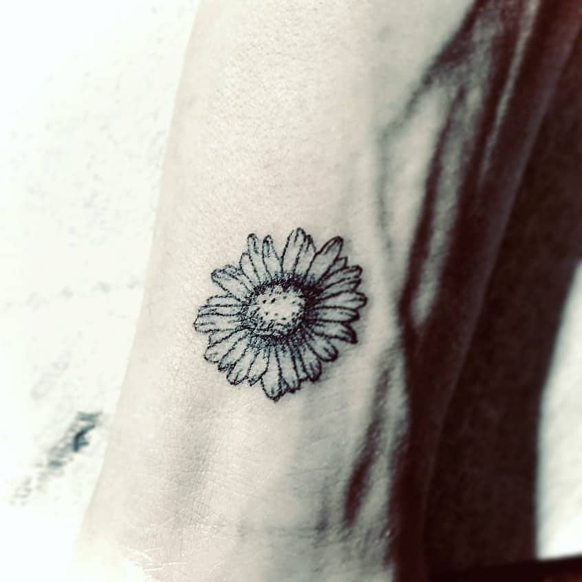 Wrist tattoo black and grey fine line daisy