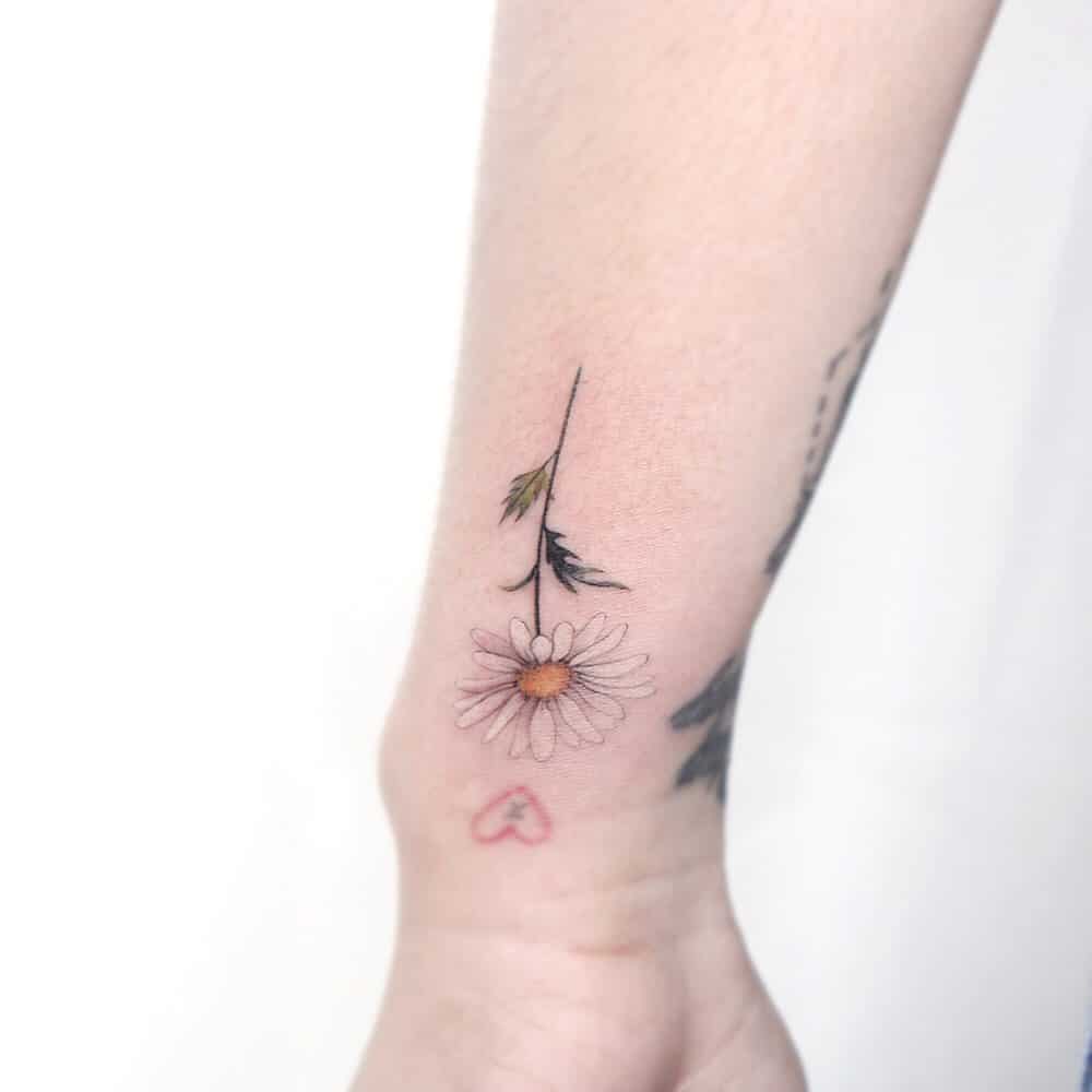 Wrist tattoo small realistic fine line white and yellow color daisy
