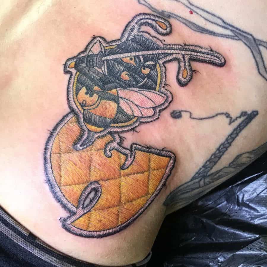 Bold embroidered tattoo of a bee warrior with a sword, integrated into a textured Wu-Tang symbol for a patch-style design.