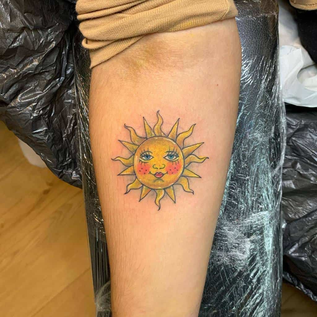 A colorful tattoo of the sun with a face on the outer forearm