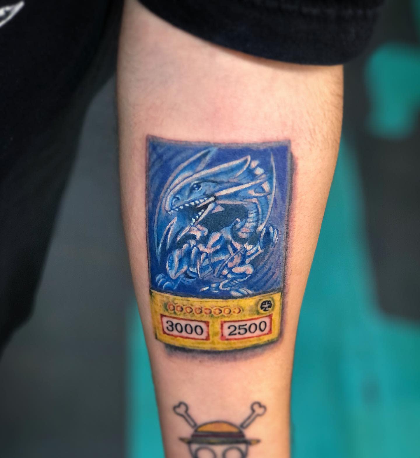Tattoo of a Blue-Eyes White Dragon Yu-Gi-Oh! card on a forearm
