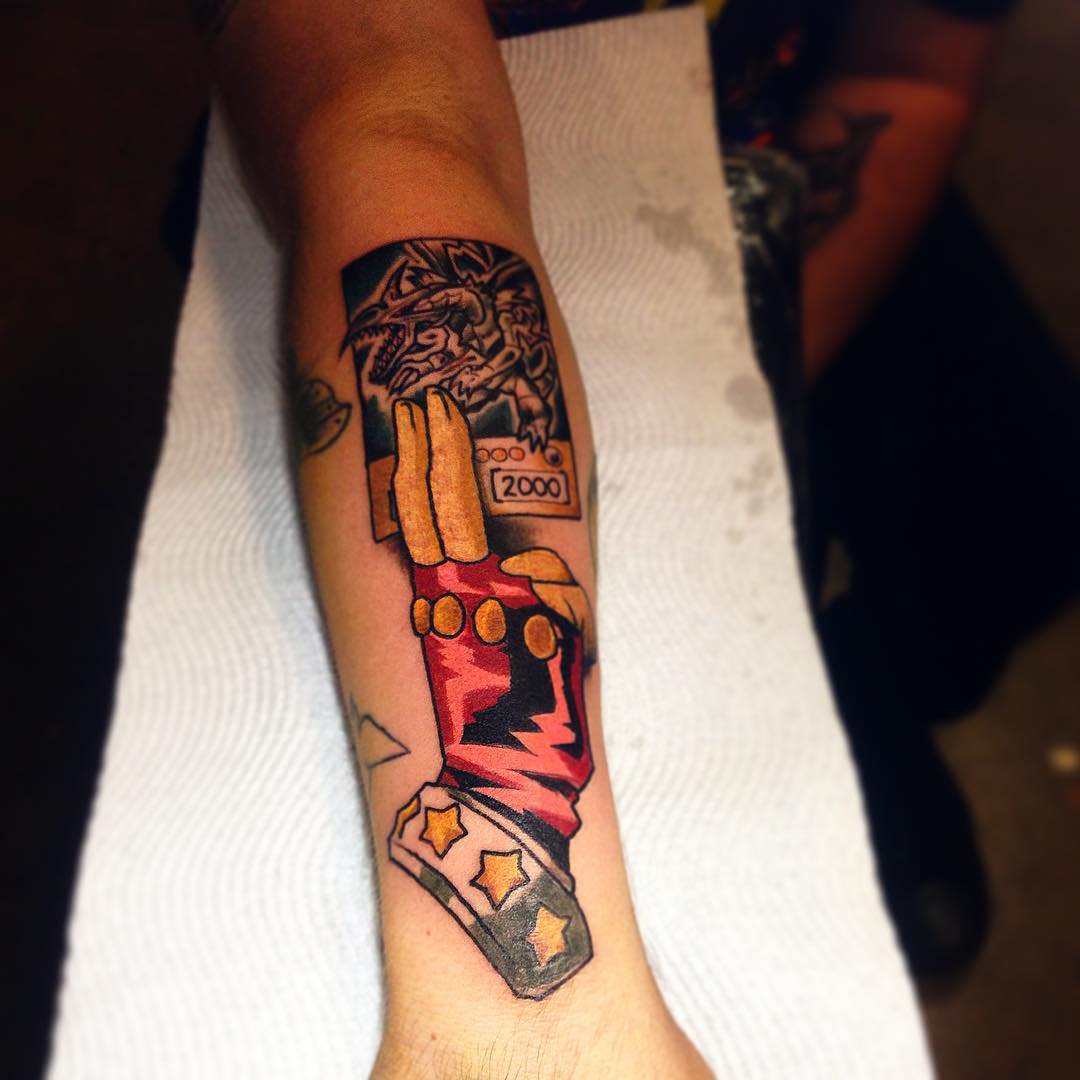 Forearm tattoo with a detailed, colorful design inspired by the "Power Glove" and robots