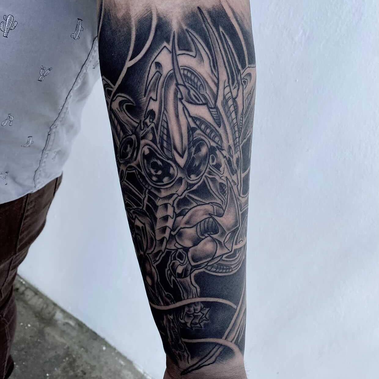 Forearm tattoo with intricate, detailed mechanical and organic designs