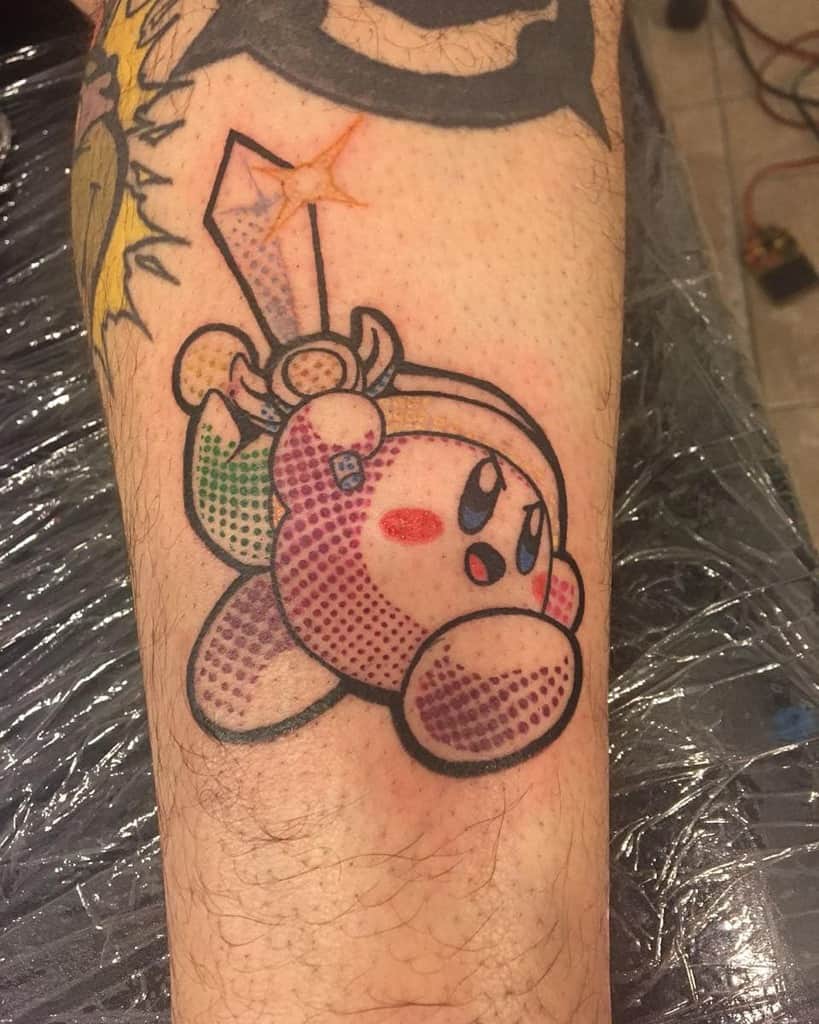 Tattoo of Kirby dressed as Link from The Legend of Zelda, wielding a sword with a glowing star, in a bold, halftone comic style