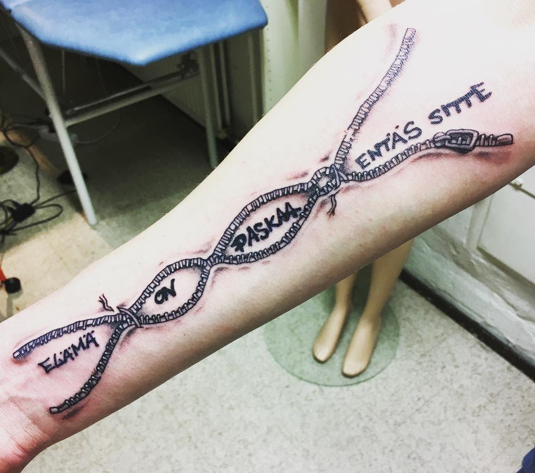 Forearm tattoo of a DNA strand with the words, "ELÄMÄ ON RASKAS ENTÄS SITTEN"