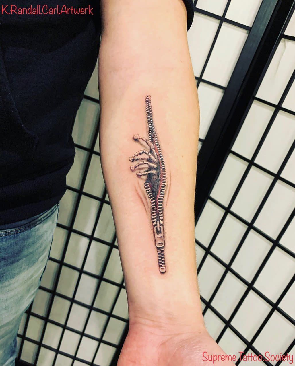 Forearm tattoo of an unzipped zipper revealing bones beneath