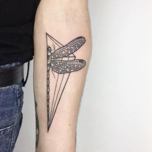 Geometric dragonfly tattoo on the forearm, featuring bold linework, intricate wing details, and a sharp triangular frame for a modern look.