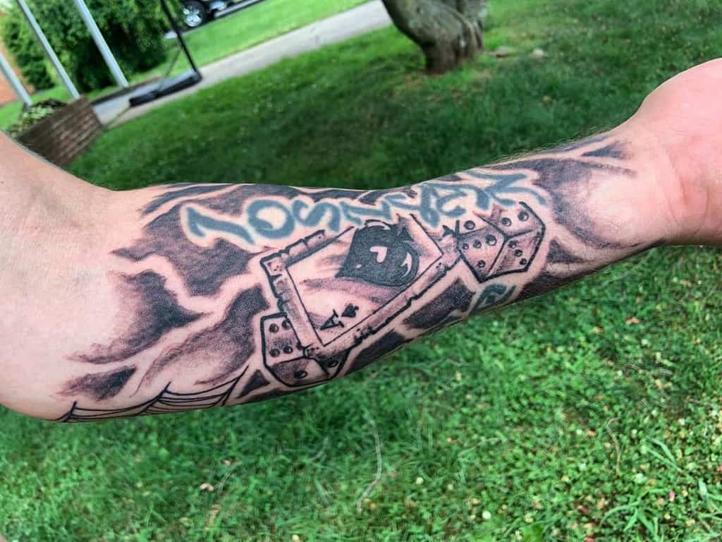 The tattoo features an ace of spades surrounded by two dice and storm-like shading, with the text Josilyn" above