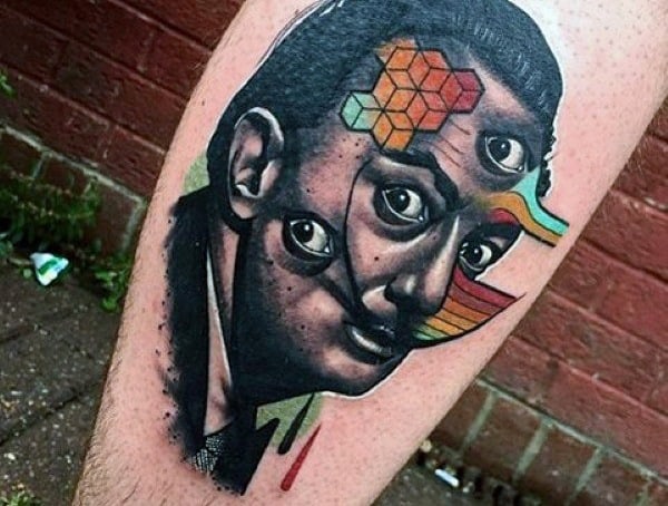 Surrealist tattoo of a man's face with multiple eyes, geometric patterns, and bold colors, blending realism with abstract and psychedelic art.
