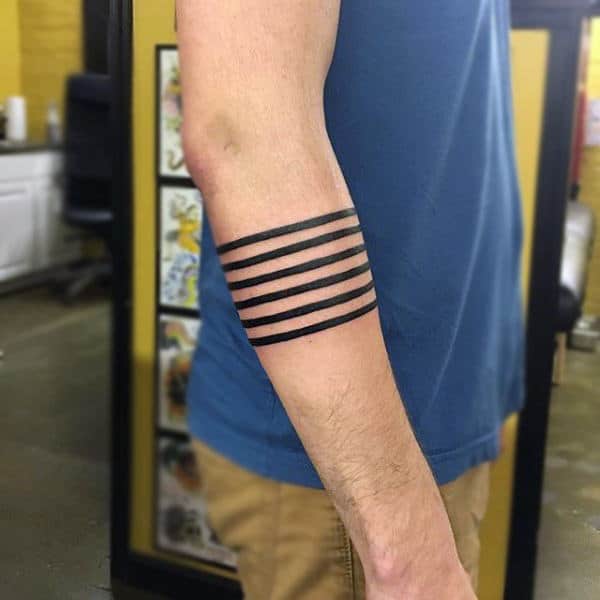 Forearm with five black armband tattoos,