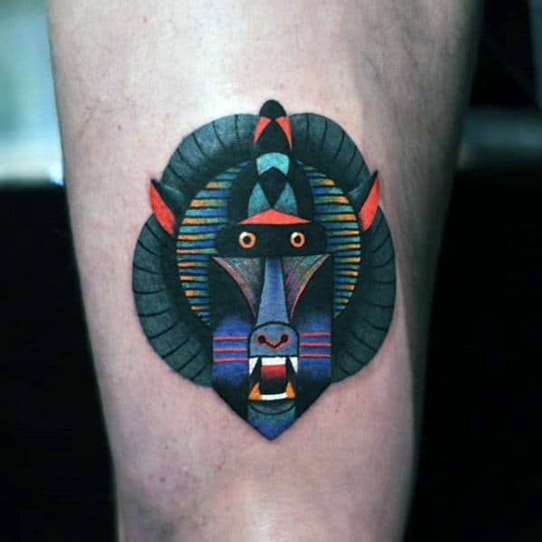 Geometric baboon tattoo with bold lines, vibrant colors, and tribal-inspired patterns, creating a modern and artistic design on the leg.
