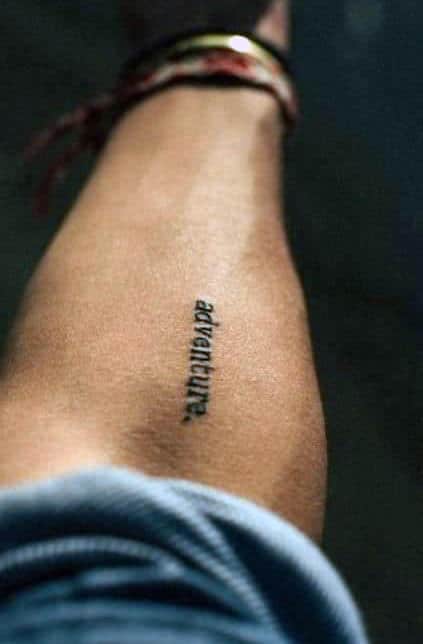 A tattoo of the word "adventure" on an arm