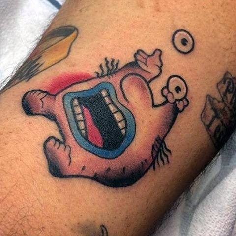 Colorful tattoo of Krumm from Aaahh!!! Real Monsters, featuring his wide open mouth and eyeballs held above his head.