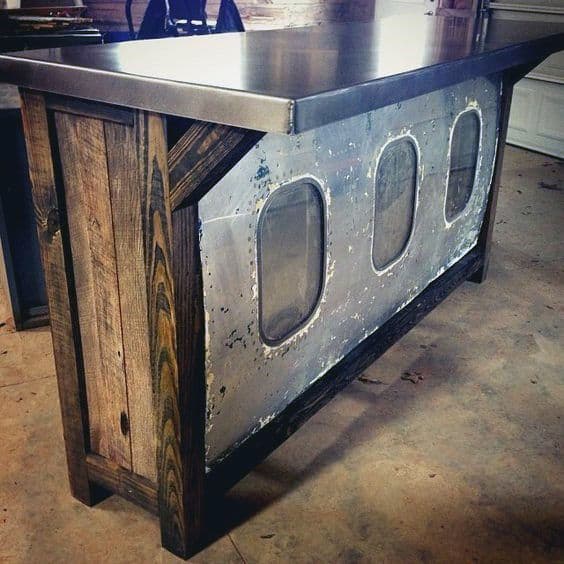 Rustic bar made from reclaimed wood and metal, featuring airplane windows as a unique design element