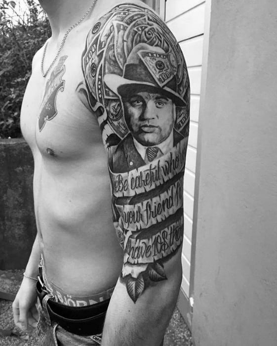 Al Capone tattoo sleeve featuring a detailed portrait of the gangster, surrounded by dollar bills and the quote "Be careful when your friend becomes your enemy."