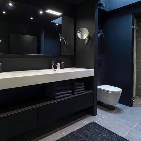 Modern all-black bathroom with sleek vanity, large mirror, and minimalist decor.
