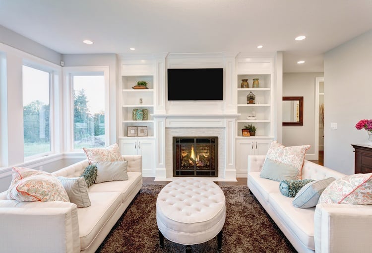 country style living room white couches ottoman white fireplace 