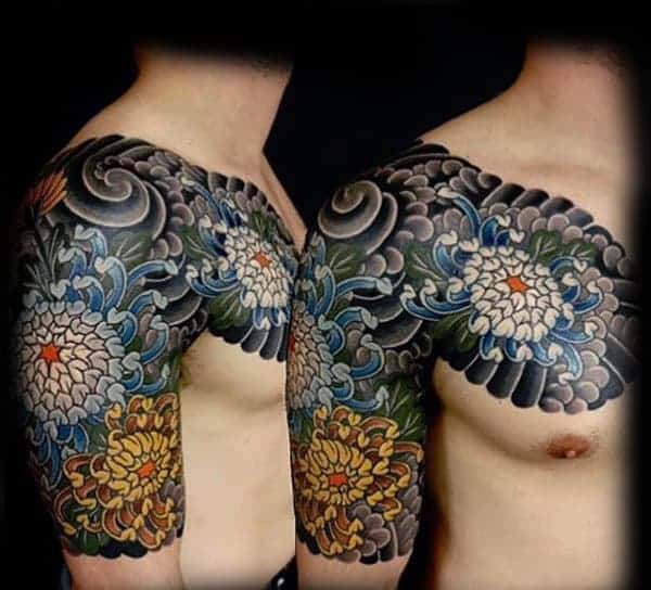 Man's shoulder and arm with colorful floral tattoos, including chrysanthemums