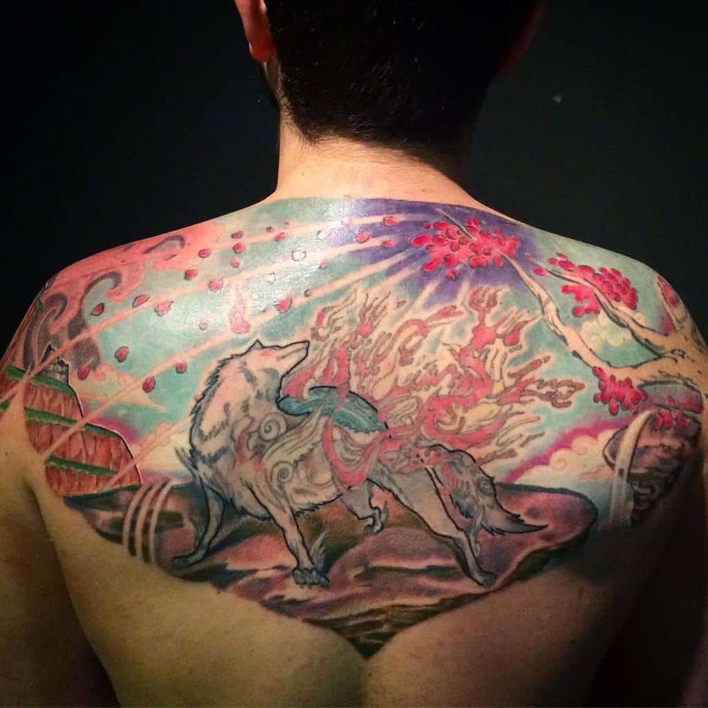 Expansive back tattoo of Amaterasu surrounded by cherry blossoms, flames, and a vivid, celestial backdrop