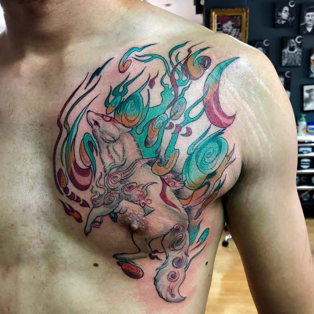 Vibrant Okami tattoo of Amaterasu with flowing celestial energy, swirling teal and orange flames, and intricate linework on the chest