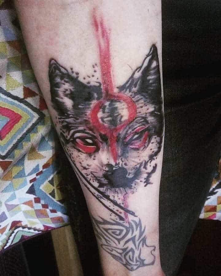 A monochromatic wolf tattoo with splashes of red ink and geometric accents, portraying a raw, intense energy