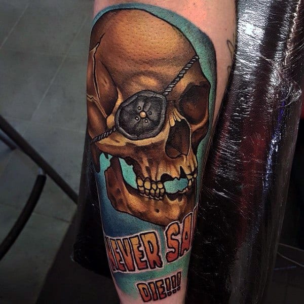 Colorful tattoo of One-Eyed Willy from The Goonies featuring a skull with an eye patch and the phrase "Never Say Die!!!" in bold letters.