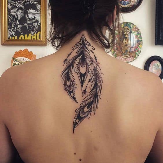 Elegant black ink peacock feather tattoo on the upper back, featuring intricate linework, ornamental details, and fine shading for a delicate look.