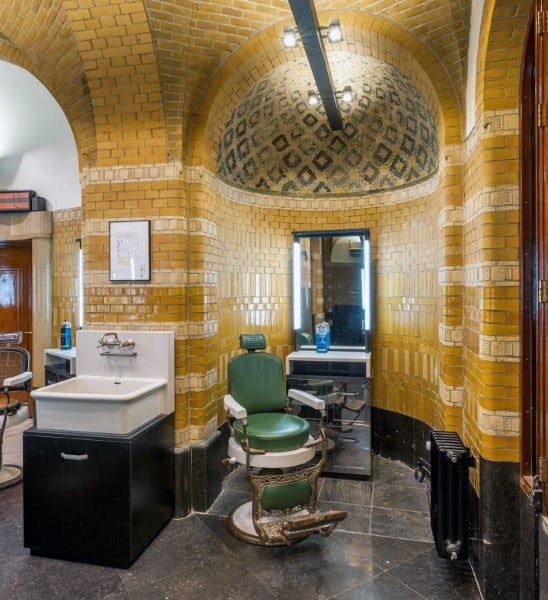 Victorian-style barbershop with vintage chair, tiled walls, and elegant sink setup.