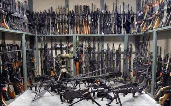 Vault filled with various firearms, including rifles, machine guns, and specialized weapons.