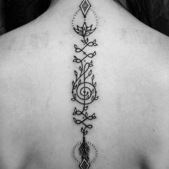 Intricate Unalome tattoo with a lotus, fire, and musical elements running down the spine, symbolizing spiritual growth, passion, and enlightenment.