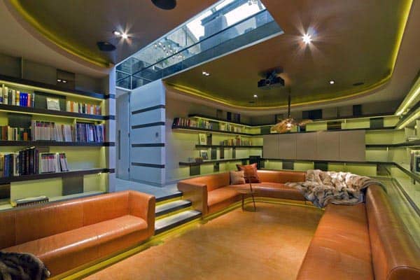 Modern library room featuring circular orange seating, bookshelves, and a skylight ceiling for natural light