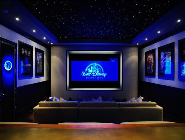 Home theater with a large screen displaying the Walt Disney Pictures logo, surrounded by movie posters and starry lights