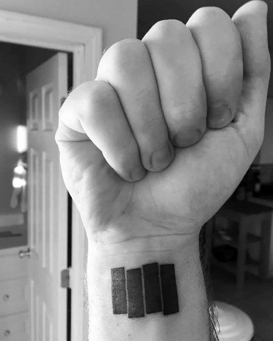 Black Flag logo tattoo on inner wrist featuring four bold black bars slightly slanted, symbolizing punk rock rebellion.