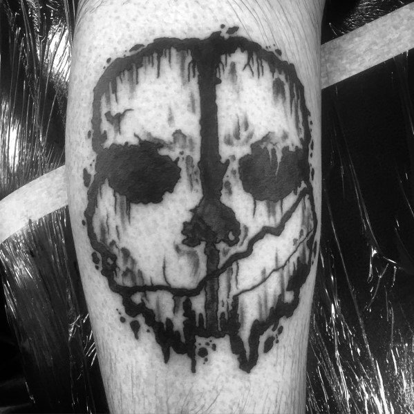 Call of Duty Ghosts skull tattoo in bold black ink with a dripping effect, creating a rugged and intense design on the leg.