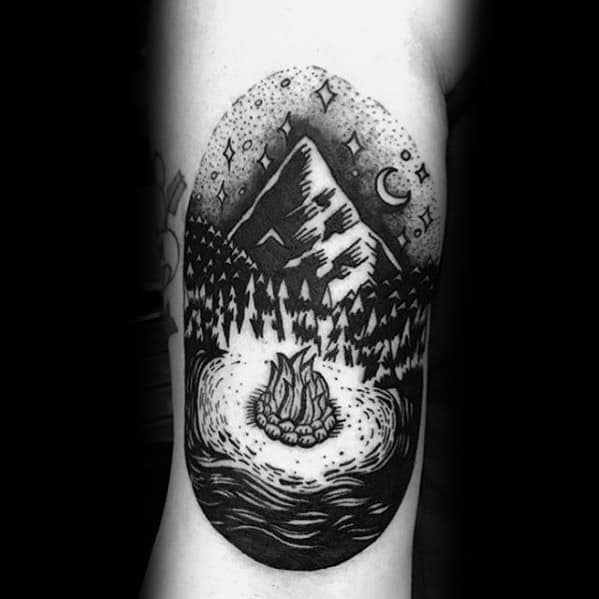 Campfire tattoo with mountains, pine trees, and night sky featuring stars and a crescent moon in blackwork style.