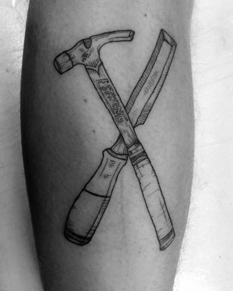Black and gray tattoo of a crossed hammer and chisel, symbolizing craftsmanship, precision, and dedication to woodworking and construction.